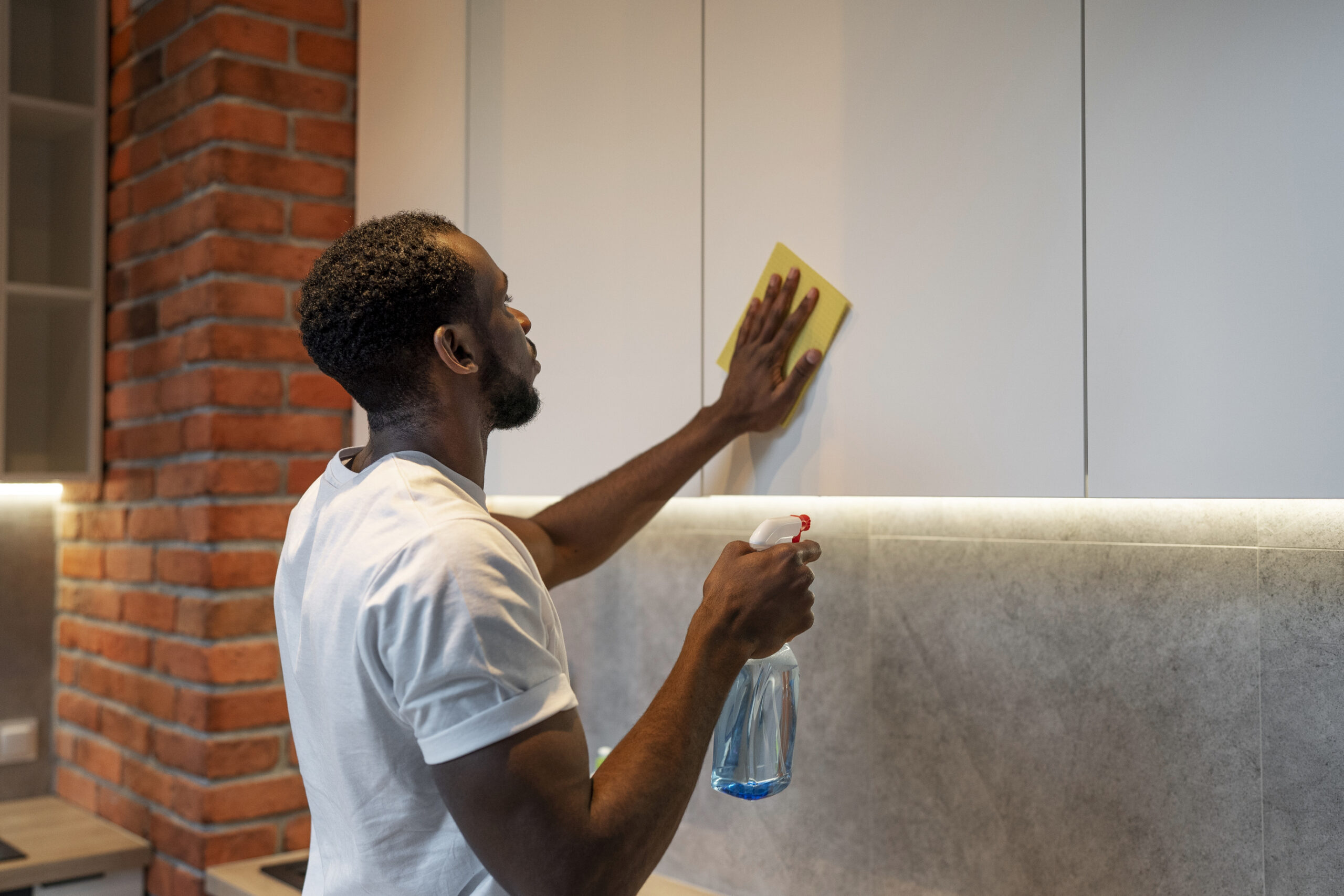 a man cleaning cabinets of a commercial building